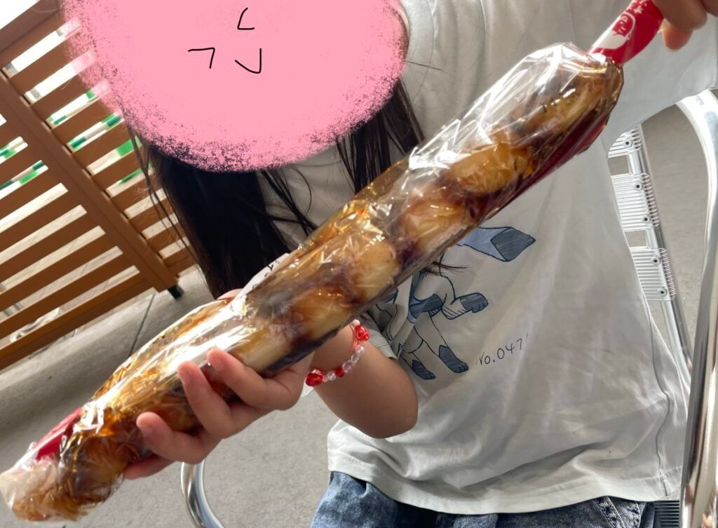 道の駅おかわまちの大筒みたらしを持つ娘