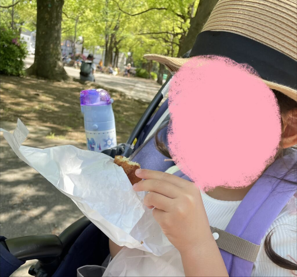 代々木公園でパンを食べる娘