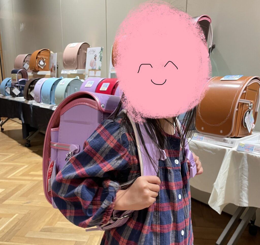 展示会で気に入ったものを背負ってみる娘